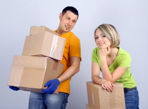 Furniture and boxes being unloaded from a van at a home