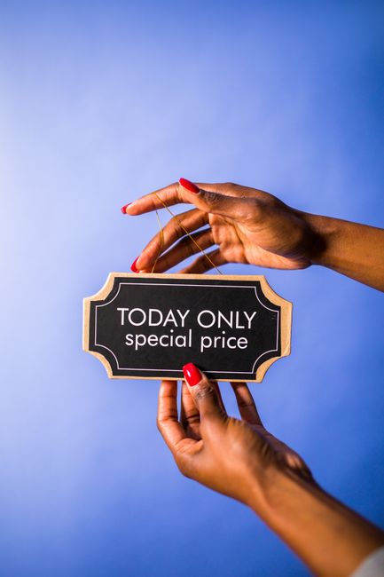 A backlit lightbox with a white frame displaying black uppercase letters that read 'COMMON SENSE NO DOUBT WINS THE DAY.' The lightbox is positioned on a dark wooden surface against a black background, illuminating the message. In front of the lightbox, a small yellow sticky note with handwritten text states 'Somewhere,' placed at a slight angle. The scene suggests a motivational or advisory message, with the setting resembling an indoor environment suitable for displaying quotes or notices related to moving or relocation planning, as seen in professional house removal services like those offered by Man with Van Barnehurst.